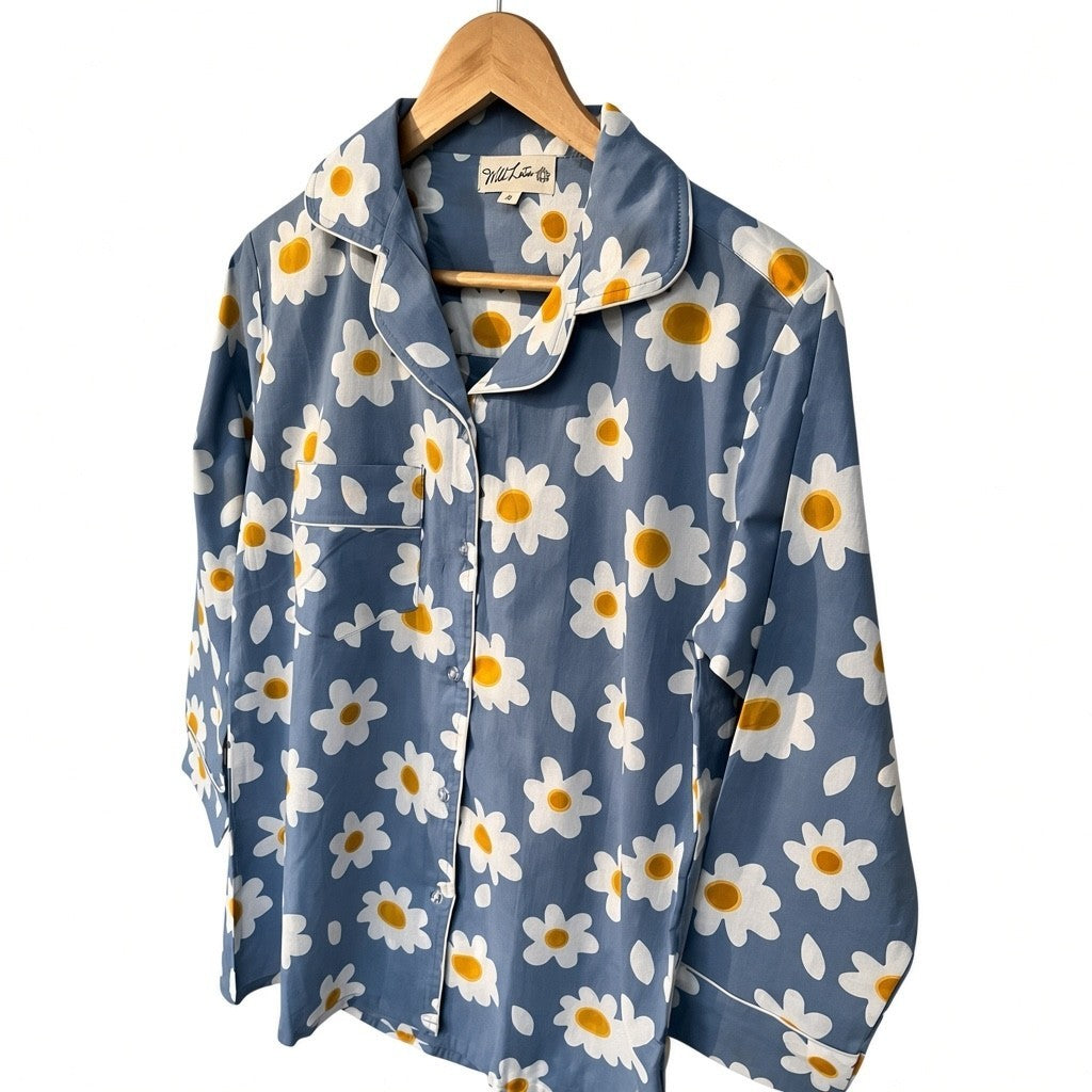 Wild Lotus UK blue cotton pyjama top with white daisy print, revere collar, chest pocket, and white piping detail.