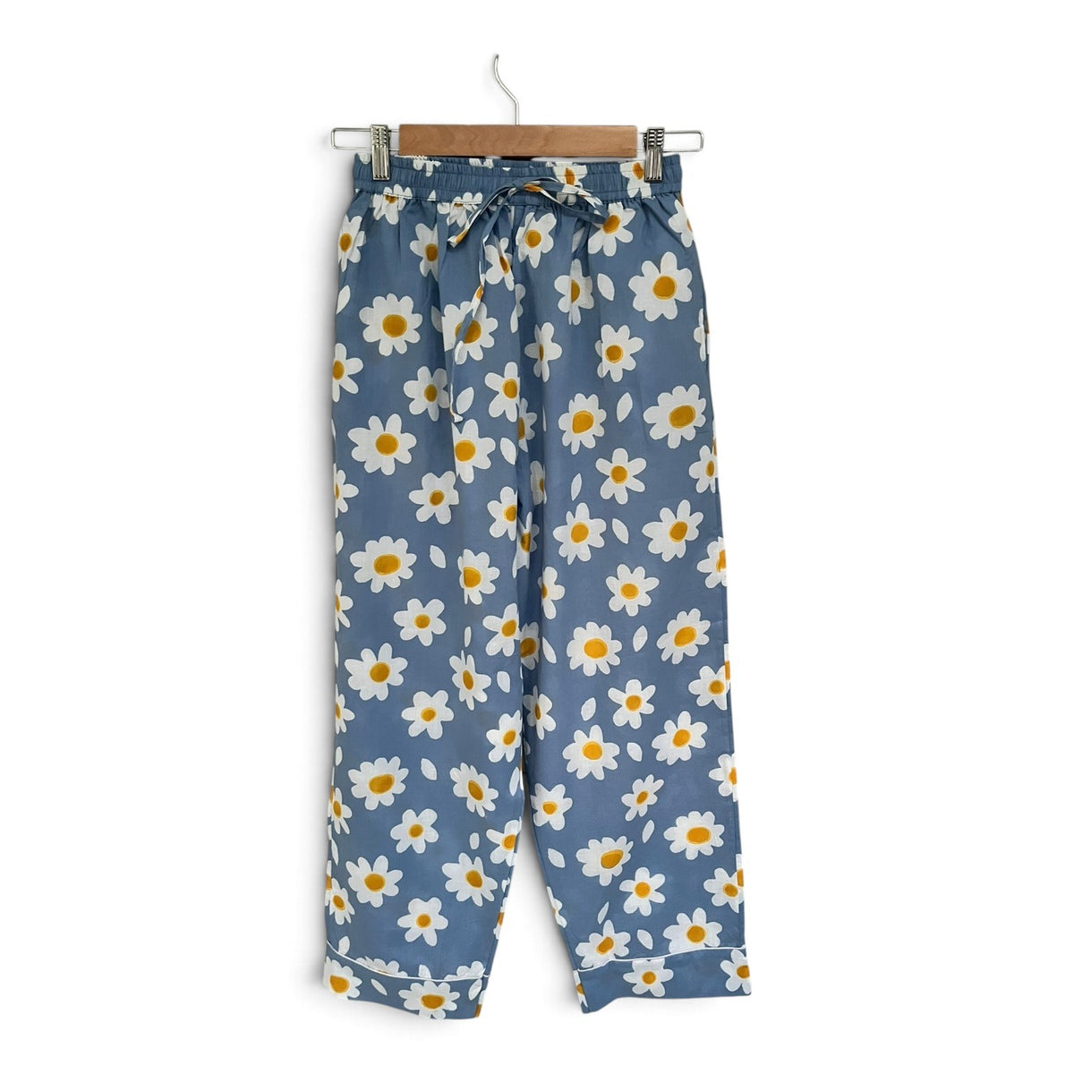 Wild Lotus UK blue cotton pyjama trousers with white daisy print, elasticated waist, and white piping detail.