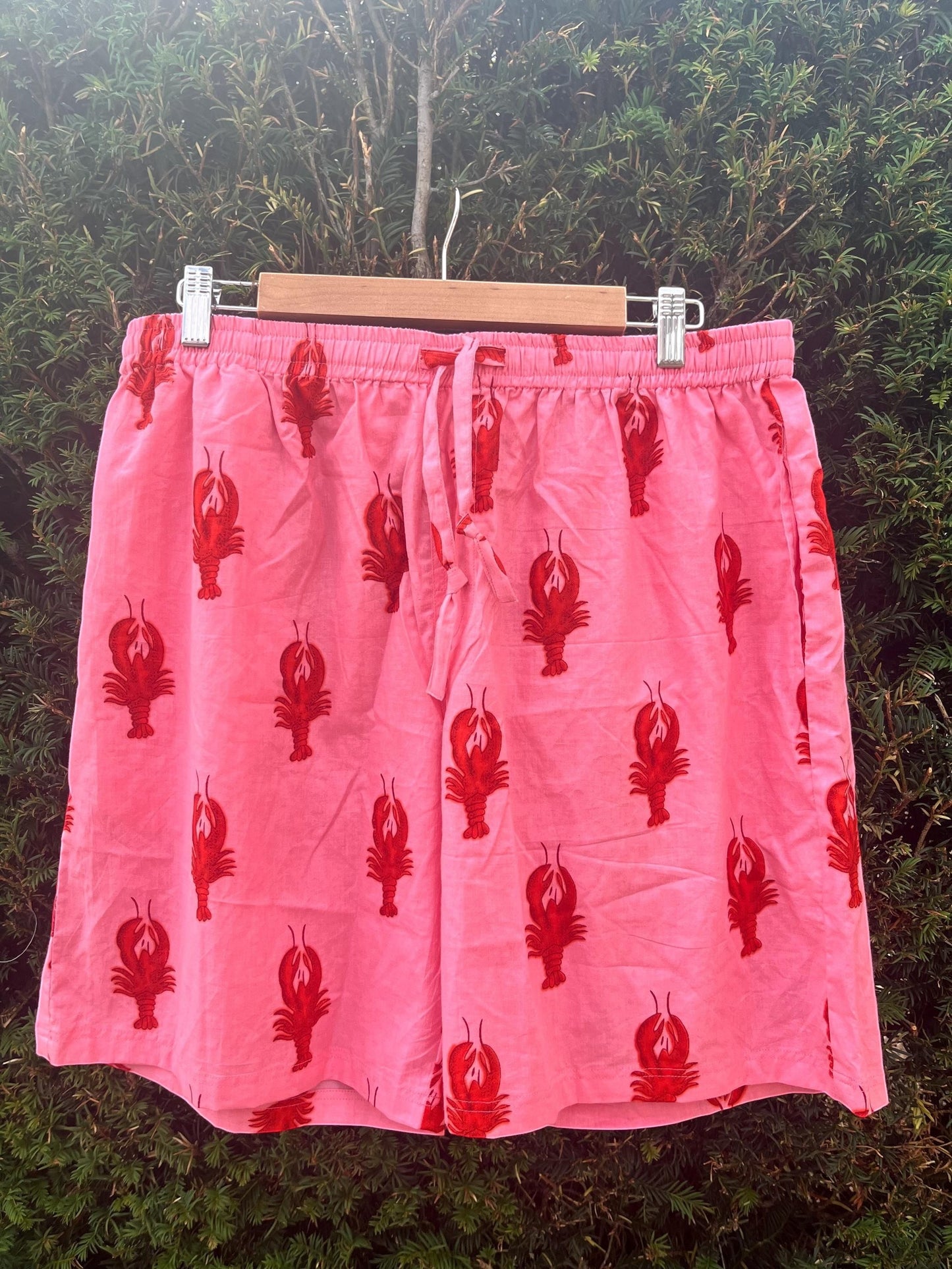 Wild Lotus UK men's pink cotton sleep shorts with a red lobster print, elasticated drawstring waist, and side pockets.