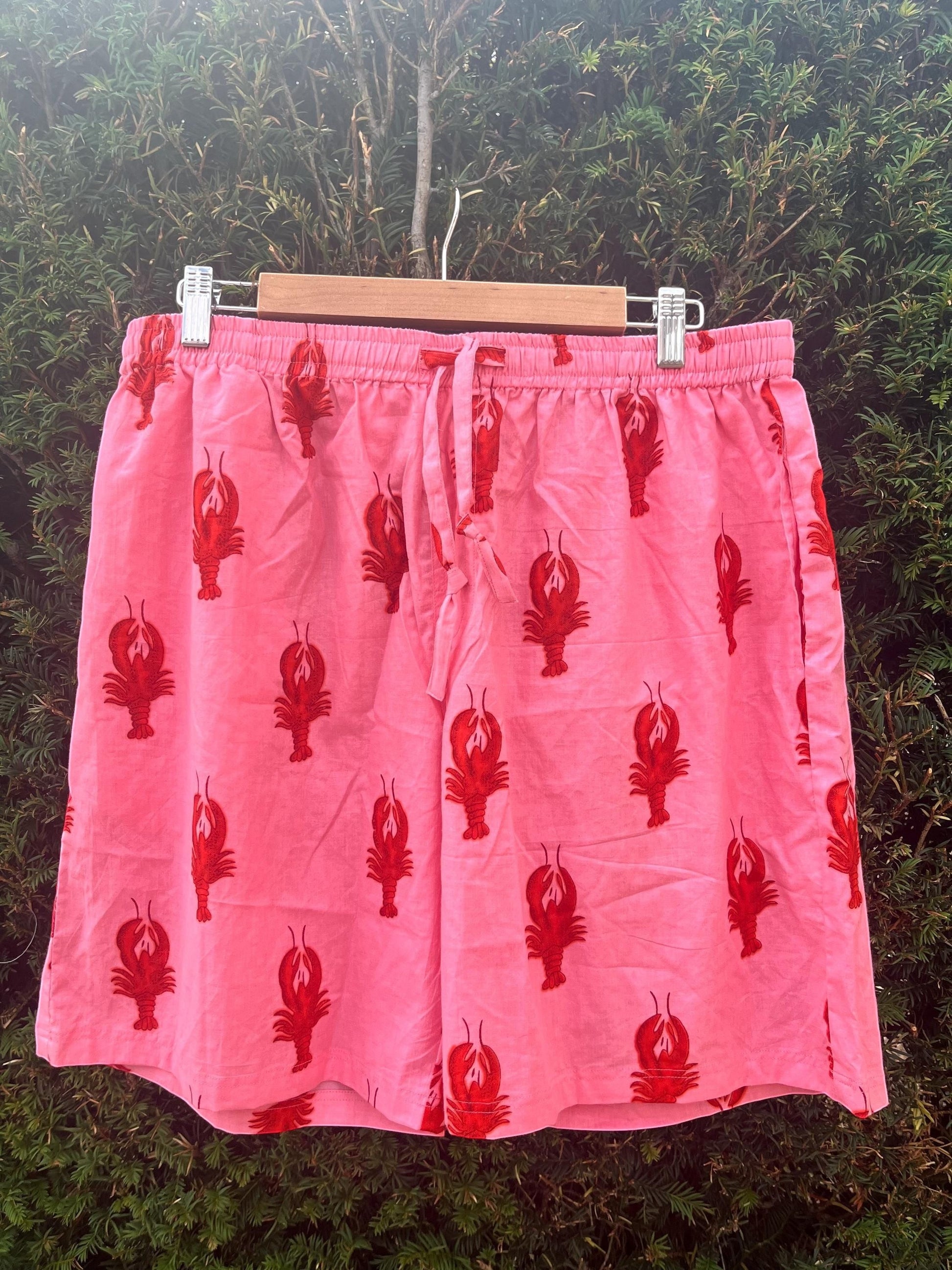 Wild Lotus UK men's pink cotton sleep shorts with a red lobster print, elasticated drawstring waist, and side pockets.